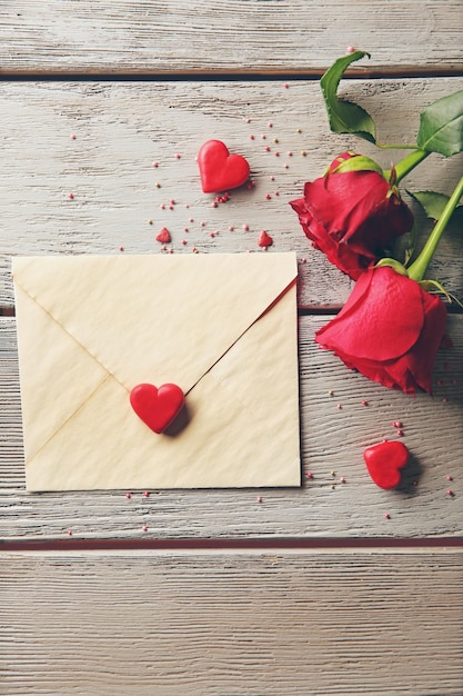 Hermosa rosa con tarjeta de regalo sobre fondo de madera