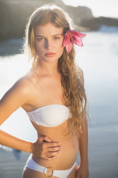 Hermosa rubia con accesorio para el pelo de flores en la playa