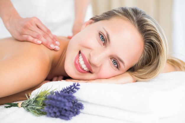 Hermosa rubia acostada en la mesa de masaje con lavanda