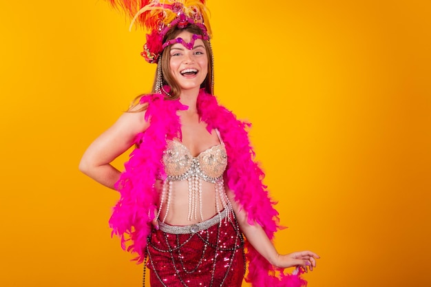 Hermosa rubia brasileña con ropa de reina del carnaval de la escuela de samba Corona de plumas con las manos en la cintura