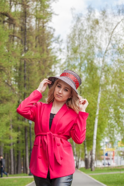 Foto hermosa rubia con chaqueta roja y sombrero city style