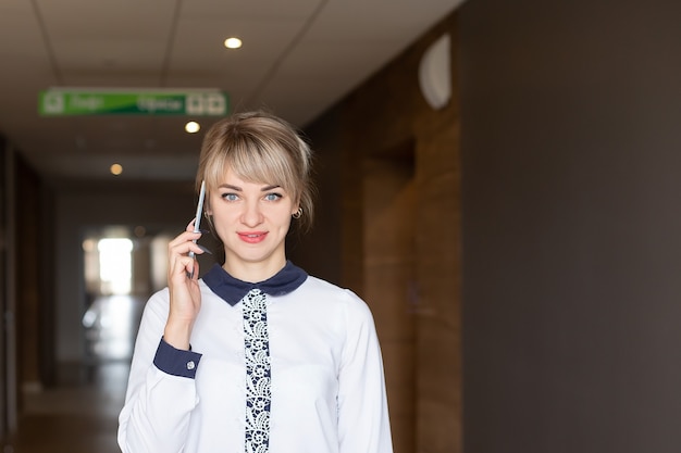 La hermosa rubia feliz hablando por teléfono