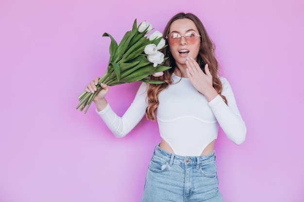 Hermosa rubia recibiendo ramo de flores para las vacaciones de primavera. concepto festivo