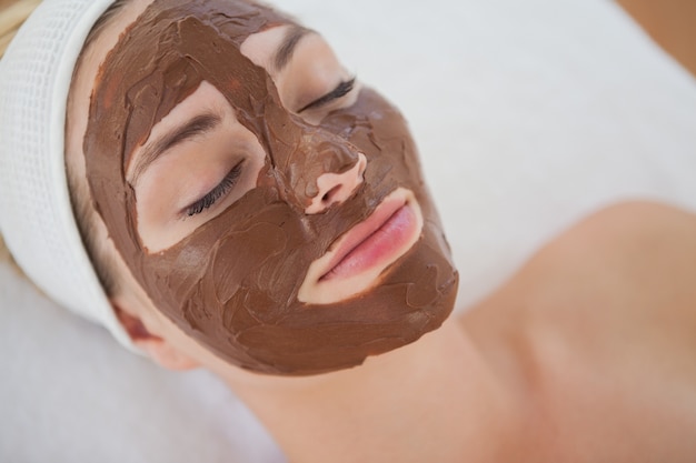 Hermosa rubia recibiendo un tratamiento facial de chocolate