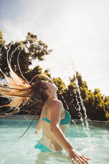 Foto hermosa rubia saliendo del agua en la piscina