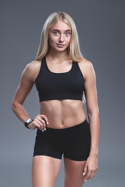 Hermosa rubia en top y shorts deportivos Ropa deportiva para atletismo