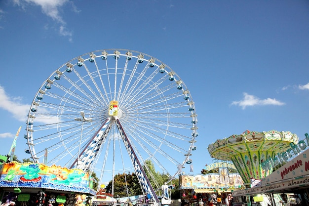 Una hermosa rueda de la fortuna en unas vacaciones rodeadas de atracciones