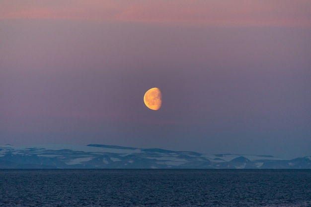 Hermosa salida de la luna en Groenlandia. Iceberg en el mar.