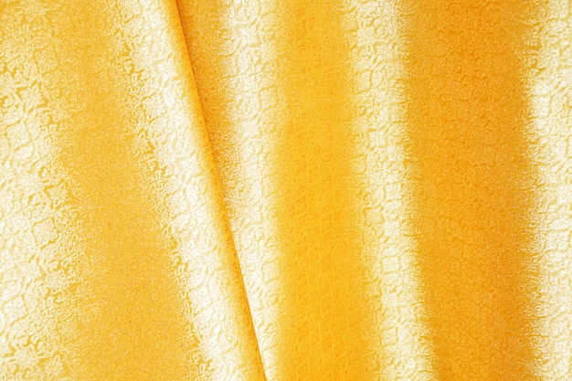 Hermosa seda de oro. Fondo de la materia textil de la pañería,