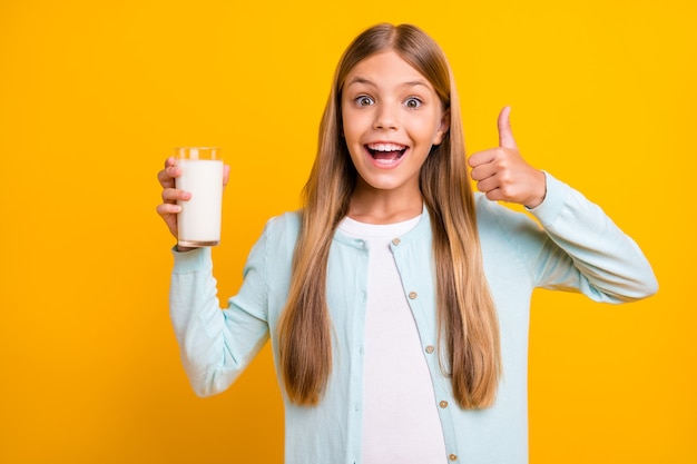 Hermosa señorita rubia sostenga el brazo levante el pulgar aconsejando la leche