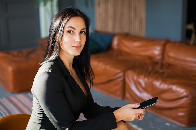 Hermosa sexy blogger con smartphone en casa.