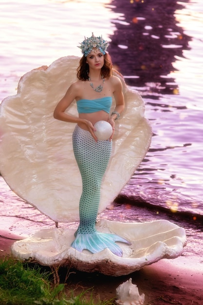 Foto una hermosa sirena está de pie en una gran concha blanca