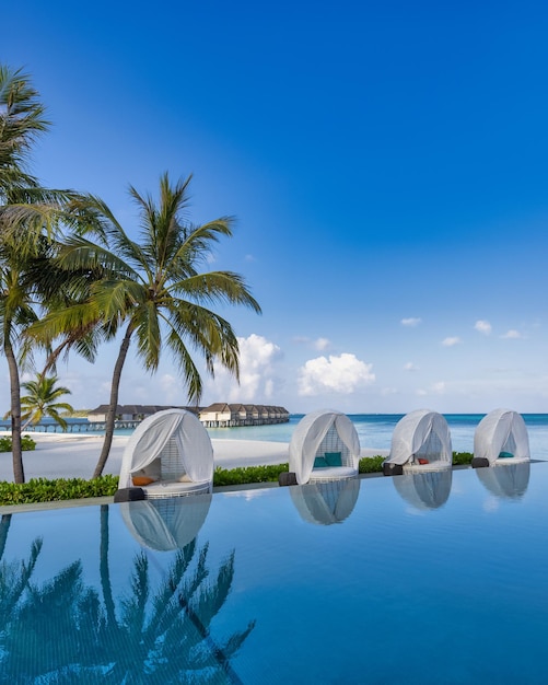 Hermosa sombrilla de lujo sillas piscina al aire libre en un resort de playa tropical, junto a la piscina tranquila