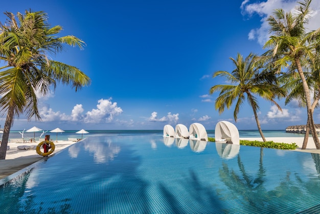 Hermosa sombrilla de lujo sillas piscina al aire libre en un resort de playa tropical, junto a la piscina tranquila