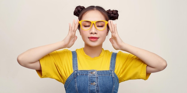 Hermosa sonriente asiático tocando gafas sobre fondo blanco.