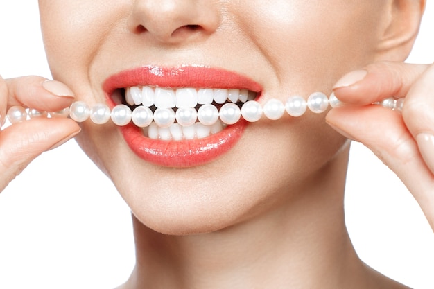 Hermosa sonrisa de dientes femeninos y collar de perlas, concepto de salud dental Blanqueamiento dental. Dental