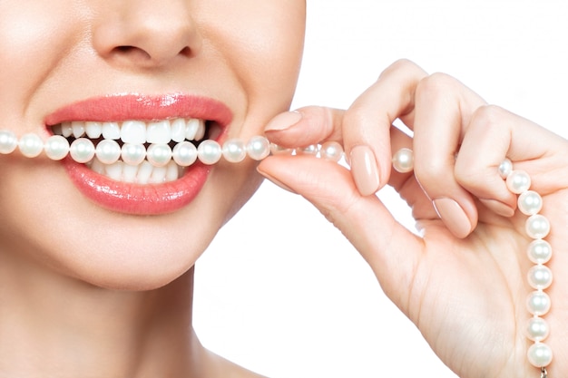 Hermosa sonrisa femenina y collar de perlas, concepto de salud dental