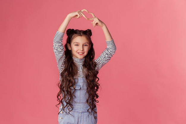 Foto hermosa sonrisa hace un signo de corazón con sus manos.