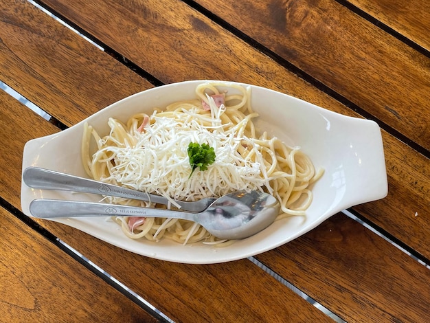 Hermosa taza de café capuchino con arte latte y spaghetti alla carbonara