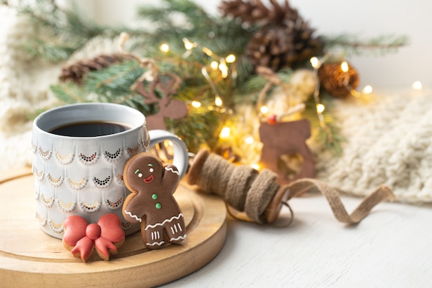 Hermosa taza con galletas de jengibre decoradas con esmalte de cerca sobre un fondo borroso con decoración.