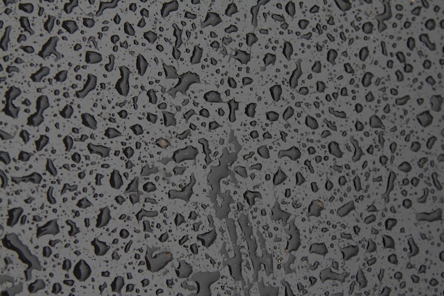 Hermosa textura de fondo de gotas de agua de lluvia en la superficie de metal negro gris