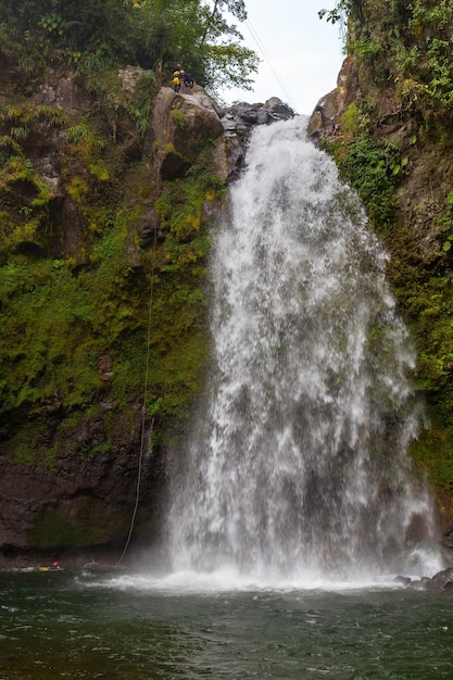 Hermosa toma verti de una cascada que fluye a través de un acantilado irregular en Xico, Veracruz, México