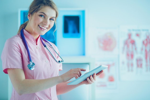 Hermosa trabajadora de la salud usando una tableta en el hospital