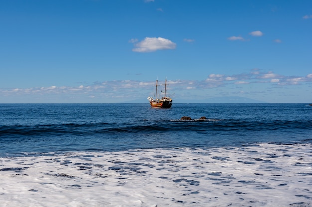 Hermosa y tranquila playa de Masca. Barco pirata llegando a la isla .. Isla volcánica. Montañas de la isla de Tenerife, Islas Canarias, España