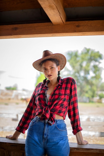 Foto hermosa vaquera vestida con un sombrero de vaquero al estilo occidental