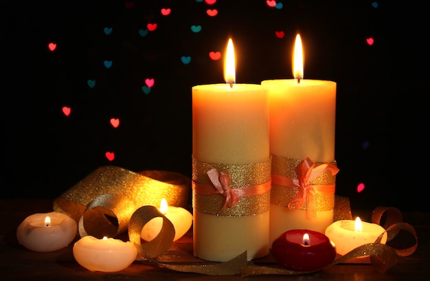Hermosa vela y decoración en mesa de madera sobre fondo brillante