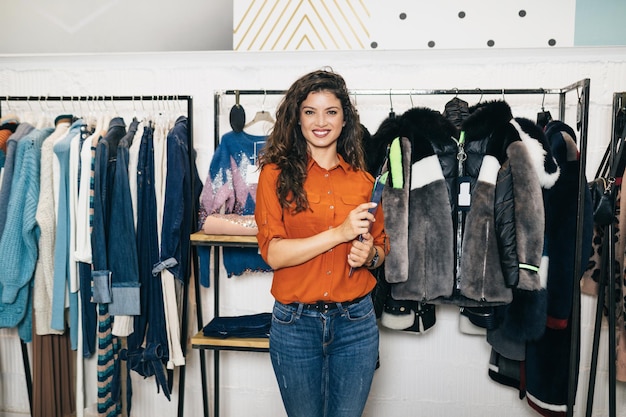 Hermosa vendedora posando en boutique o tienda exclusiva.