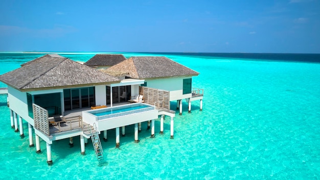 Hermosa villa de agua de Maldivas en laguna azul y espacio de cielo azul