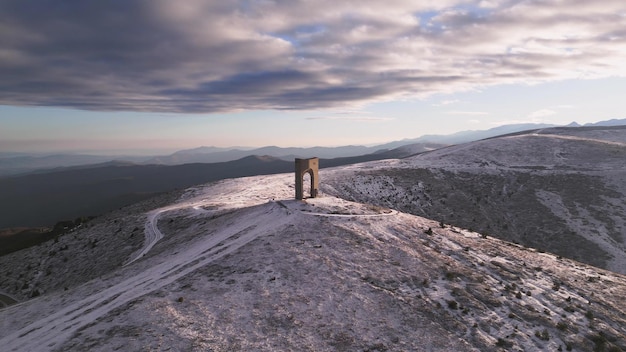 Hermosa vista aérea de las montañas cubiertas de nieve y el Monumento Arco de la Libertad Bulgaria