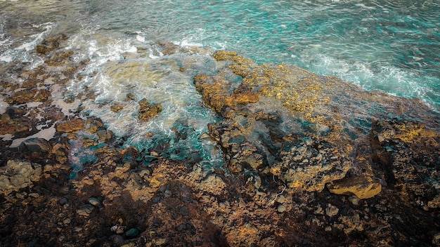 hermosa vista aérea de las olas del mar. Colores azules y espuma blanca en un agua peligrosa viva con la línea de la costa de las rocas y ningún ser humano