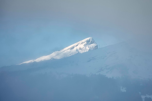 Hermosa vista de los Alpes berneses cubiertos de nieve durante la niebla