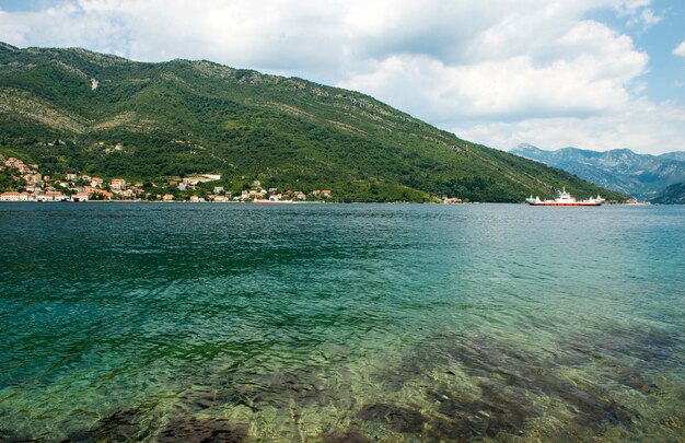 Hermosa vista desde arriba a la bahía de Kotor y ferry de pasajeros regular de Lepetane a Kamenari en una tarde soleada.