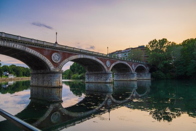 Hermosa vista del atardecer del puente de arco sobre el río Po en la ciudad de Turín Italia