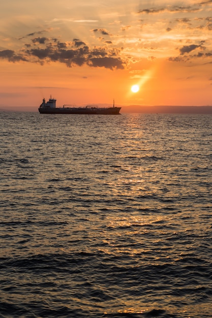 Hermosa vista del atardecer sobre el mar y la silueta del barco