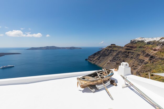 Hermosa vista de la caldera blanca de Santorini en Grecia. Barco de madera en la famosa escena de la arquitectura blanca