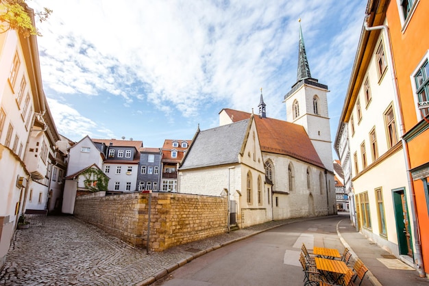 Hermosa vista de la calle con coloridos edificios y la torre de la iglesia en el casco antiguo de la ciudad de Erfurt durante la luz de la mañana en Alemania