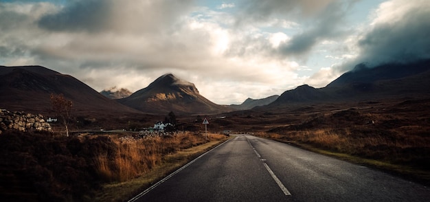 Foto hermosa vista de una carretera con montañas y un cielo nublado