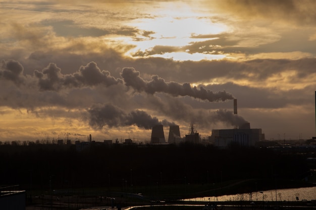 Foto hermosa vista de las chimeneas humeantes de la central térmica al atardecer