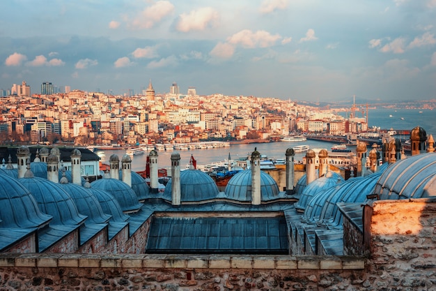 Hermosa vista del cuerno de oro al atardecer, Estambul, Turquía. Los tejados de la mezquita de Suleymaniye en los rayos del sol poniente contra el mar azul en Estambul