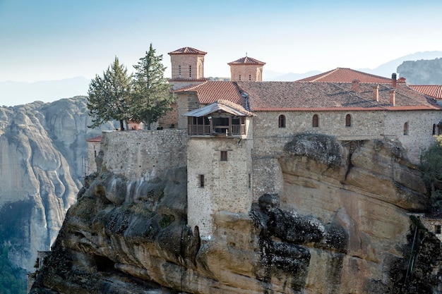 Hermosa vista escénica Monasterio ortodoxo de Varlaam inmenso pilar monolítico follaje verde al fondo de la pared de piedra en las montañas de Meteora Pindos Tesalia Grecia Europa