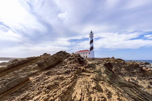 Hermosa vista del faro bajo el cielo con nubes en la isla de Menorca