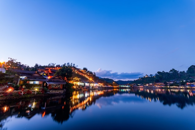 Hermosa vista de las luces del atardecer de colinas y edificios chinos en Rak Thai Village en Ban Rak Thai