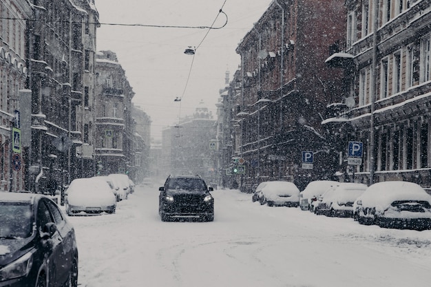 Hermosa vista de la maravillosa ciudad nevada con automóviles cubiertos de nieve