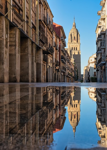 Una hermosa vista matutina de la torre de la catedral de Salamanca reflejada en el agua de lluvia - España