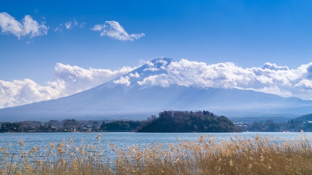 Foto una hermosa vista de la montaña fuji con nieve y nubes cubriendo la cima.