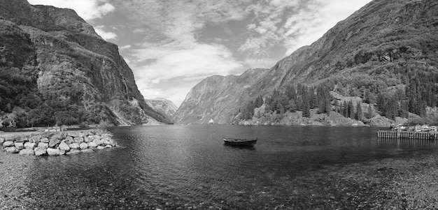 Hermosa vista de la naturaleza con bosque verde en las montañas con barco en el agua del canal del mar de noruega sobre fondo de cielo azul